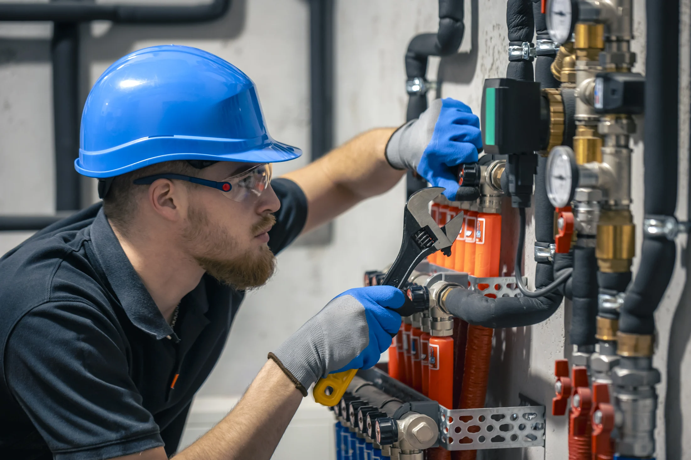 Plumber adjusting heating valves in a residential building